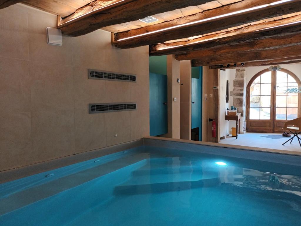 a swimming pool in a house with a pool at La Clé des Sens in Castelnau-Pégayrols
