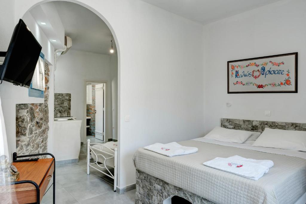a bedroom with a bed and a tv in a room at Politimis Studio N5 in Amorgos