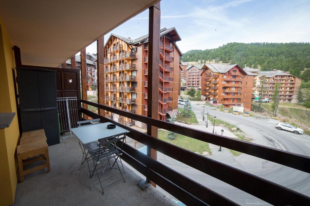 a balcony with a table and chairs on a balcony at Appartemment 6 couchages Risoul in Risoul