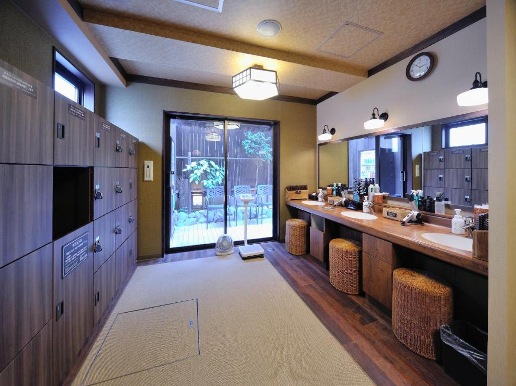 a large bathroom with two sinks and a large window at Dormy Inn Akihabara in Tokyo
