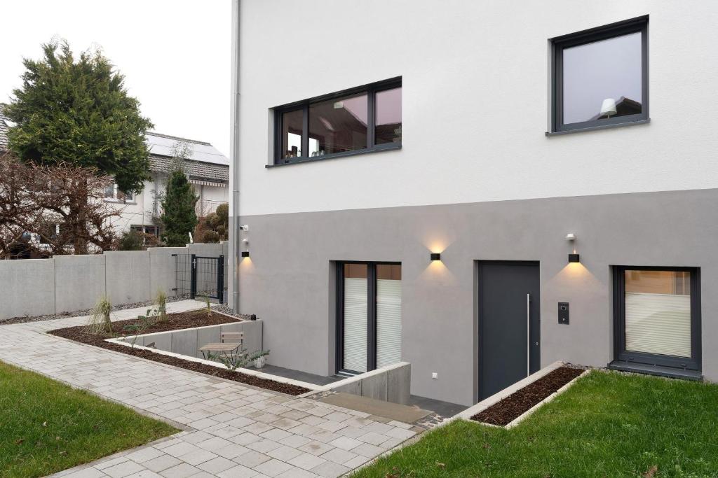 a white house with black windows and a yard at Meerrettichnest in Appenweier