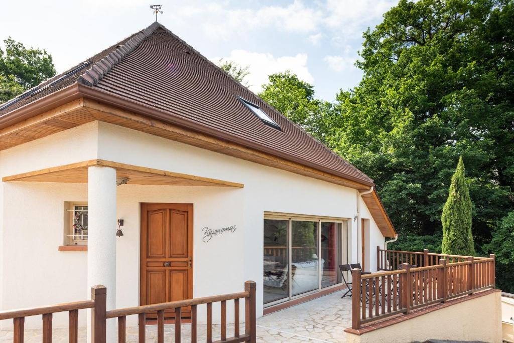 ein kleines weißes Haus mit einer Holztür in der Unterkunft Maison Zen dans les Pyrénées in Coarraze