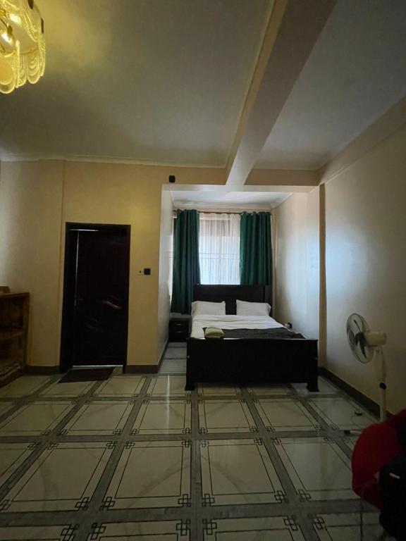 a large bedroom with a bed and a window at Alz Haven in Jinja