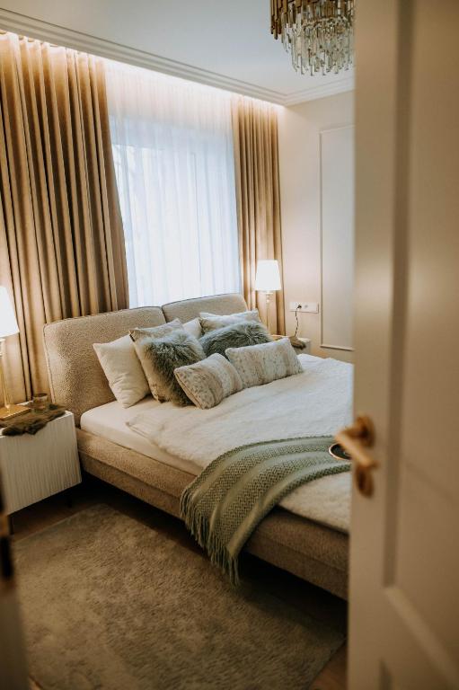a bedroom with a bed with pillows and a window at Apartament Kościuszki Nowa Sól in Nowa Sól