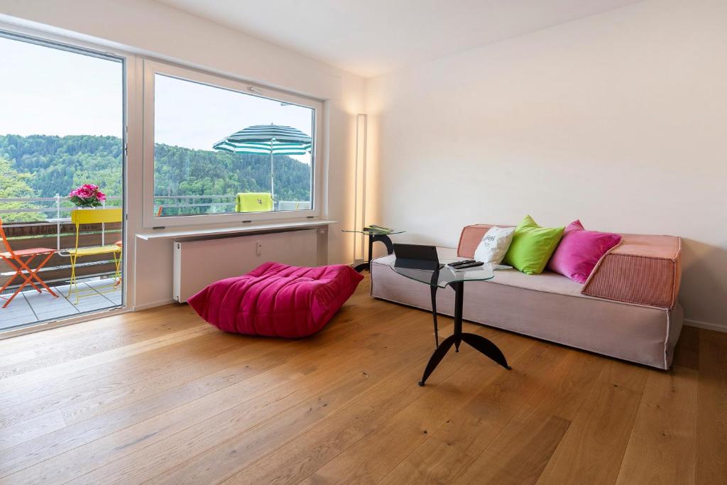 a living room with a couch and a large window at Traumblick in Bad Liebenzell