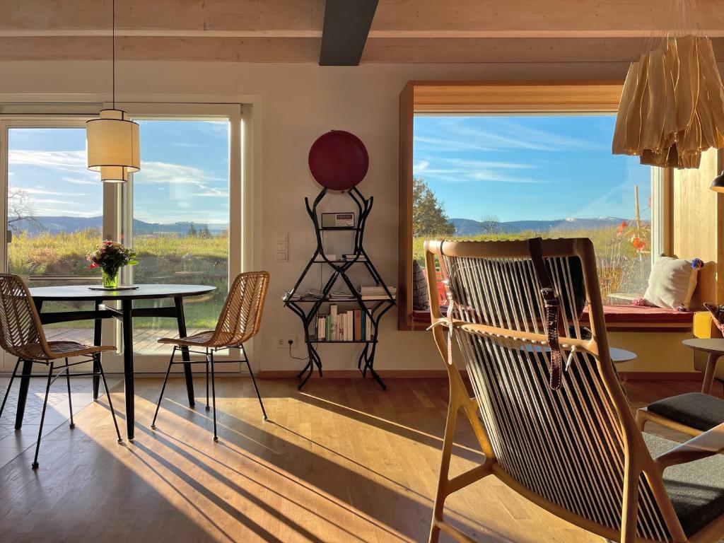 a dining room with a table and chairs and a large window at Ferienwohnung Waldmeisterzimmer in Sankt Peter