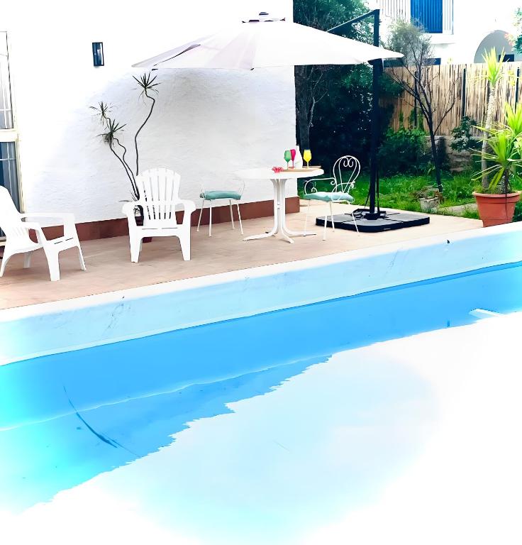 a pool with chairs and a table and an umbrella at Villa Nonna Anna a Plemmirio in Syracuse