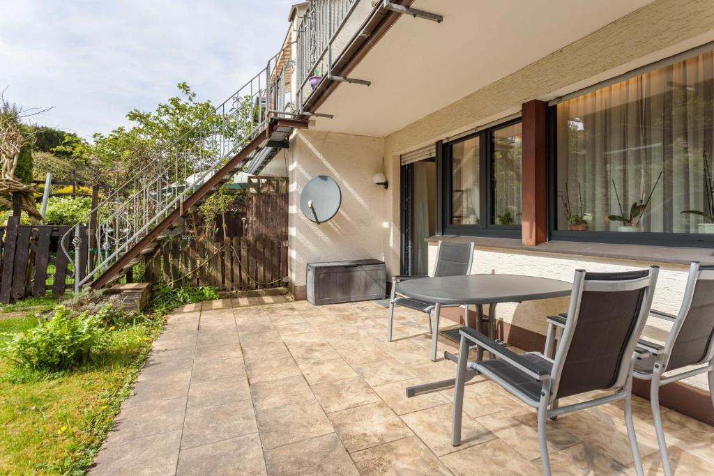a patio with a table and chairs in front of a house at Ferienwohnung Figelius in Herscheid