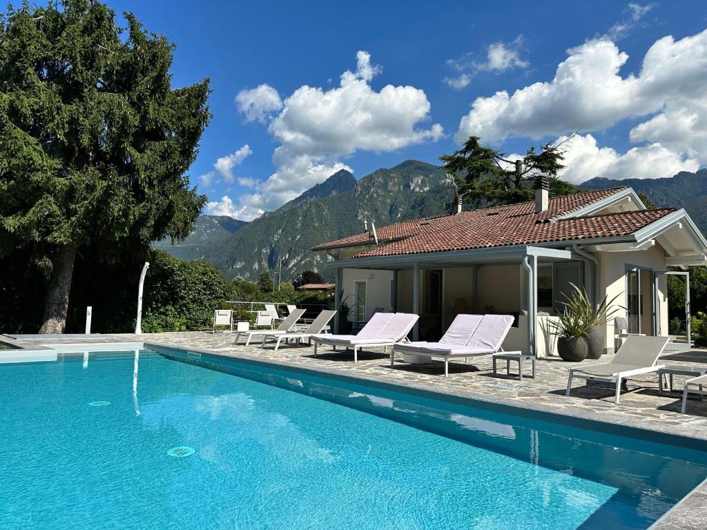 a villa with a swimming pool in front of a house at Villa Romantica Lake Idro in Bagolino