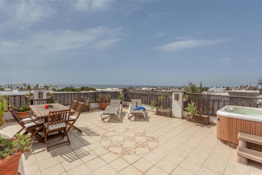 a patio with a table and chairs and a hot tub at Penthouse con Jacuzzi in Costa Teguise