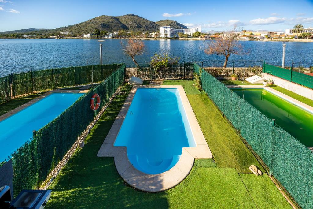 an overhead view of a swimming pool next to a body of water at Llac D'alcudia in Port d'Alcudia