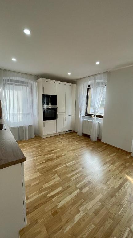 an empty living room with wooden floors and white cabinets at Max Haus 2 in Karlstadt