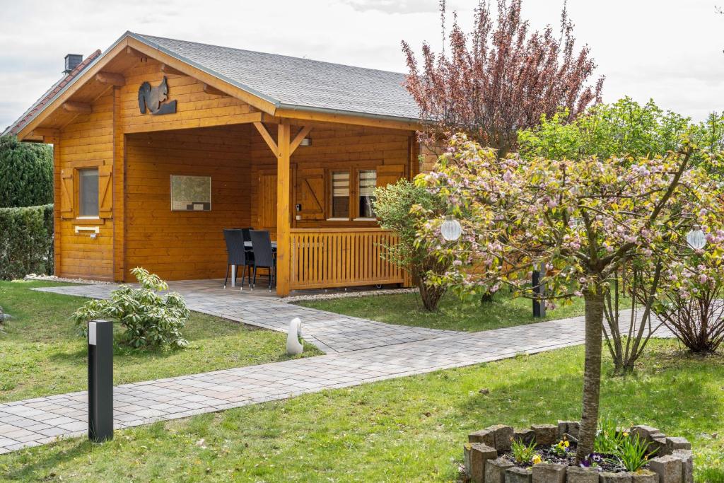 a wooden cabin with a tree in front of it at Ferienhaus 4 Familie Täubert in Klein Uhyst