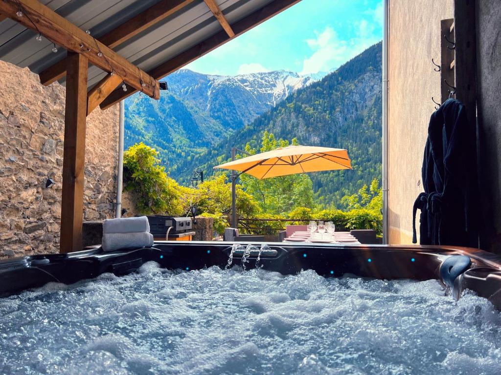 a jacuzzi tub with a view of a mountain at Jacuzzi Sauna Terrasse Venosc in Les Deux Alpes