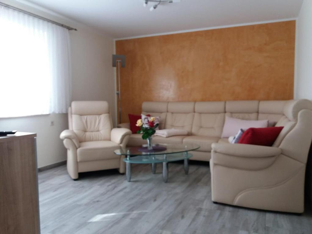 a living room with a couch and two chairs and a table at Müritz - Domizil in Waren