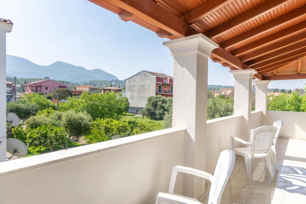 ein Balkon mit weißen Stühlen und Aussicht in der Unterkunft Olivea Apt 4 in Acharavi