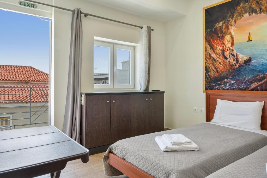 a bedroom with a bed and a large window at Motel katerina in Keratea