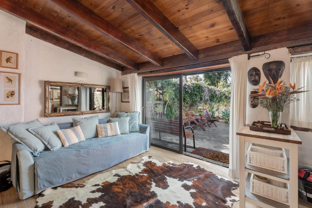 a living room with a blue couch and a large window at Casa Palmera - Private Paradise in Tacoronte