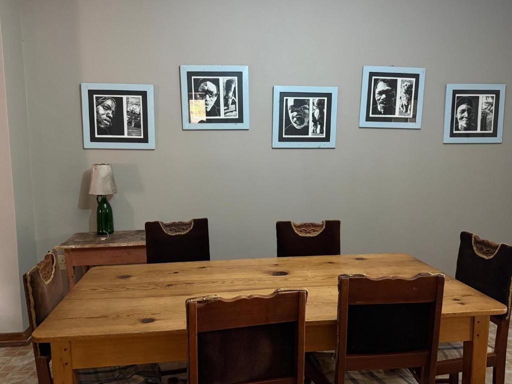 a dining room with a wooden table and chairs at Venterspoort Farmhouse in Philipstown