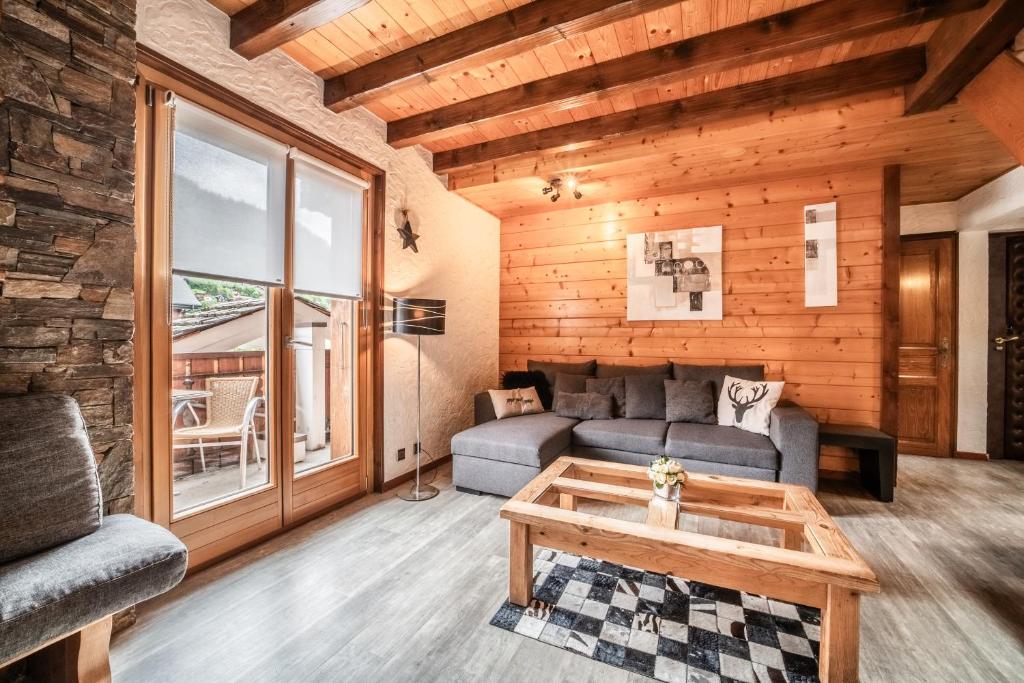 a living room with a couch and a table at Appartement chalet - Le Caribou in Morzine