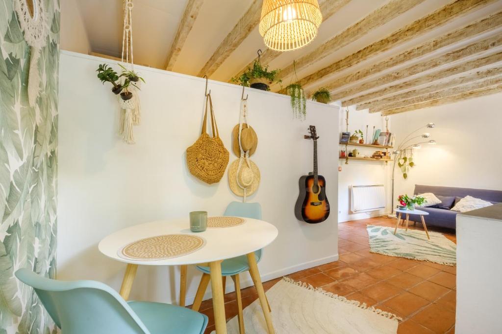 a kitchen and living room with a table and chairs at Le Jardin des Oiseaux in Clans