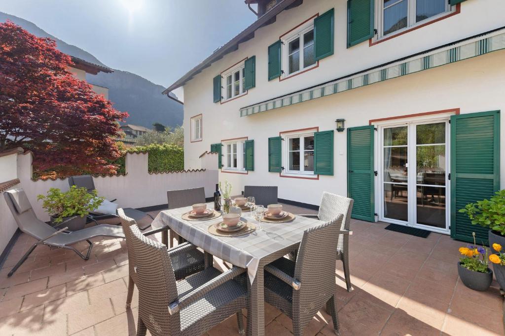 a patio with a table and chairs and a building at Apartment Kreutnerbinderhof in Terlano