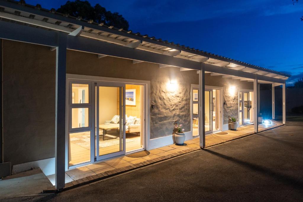a house with sliding glass doors on a patio at night at The Palm Suites in Meadowridge