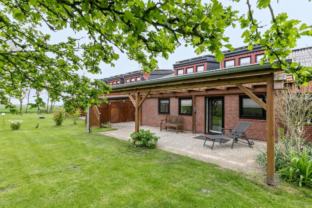 a brick house with a pavilion in a yard at Ferienhof Littmann in Friedrich-Wilhelm-Lübke-Koog