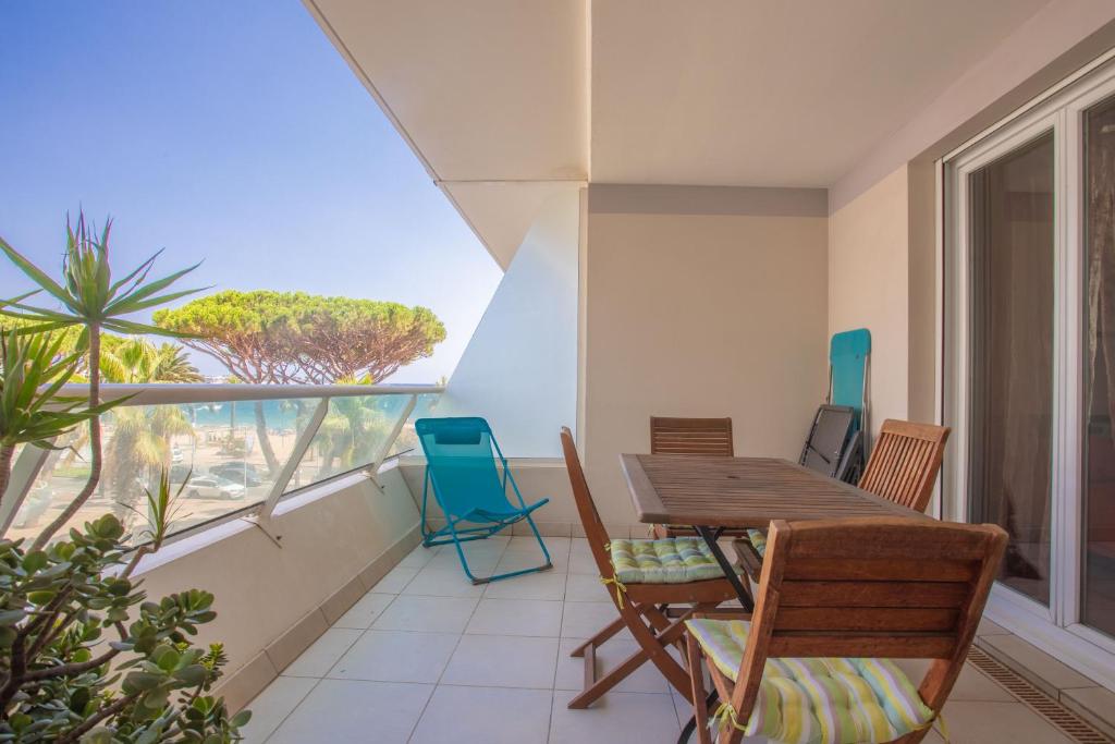 a dining room with a table and chairs on a balcony at Superbe Appartement vue mer in Fréjus