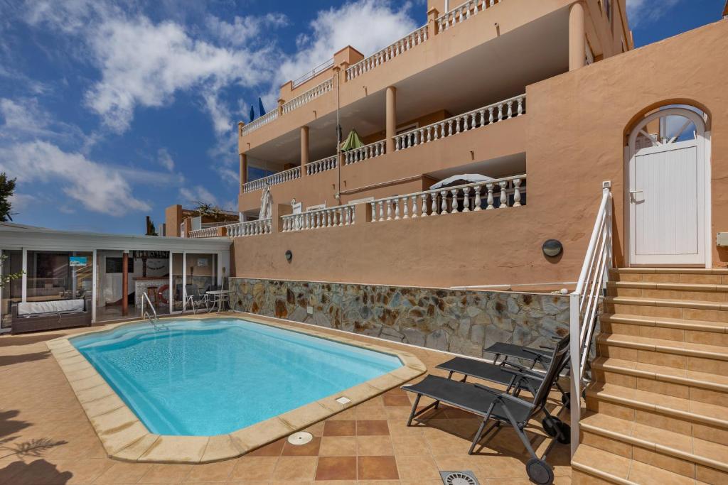 a villa with a swimming pool and a house at Casa Marron in Costa Calma