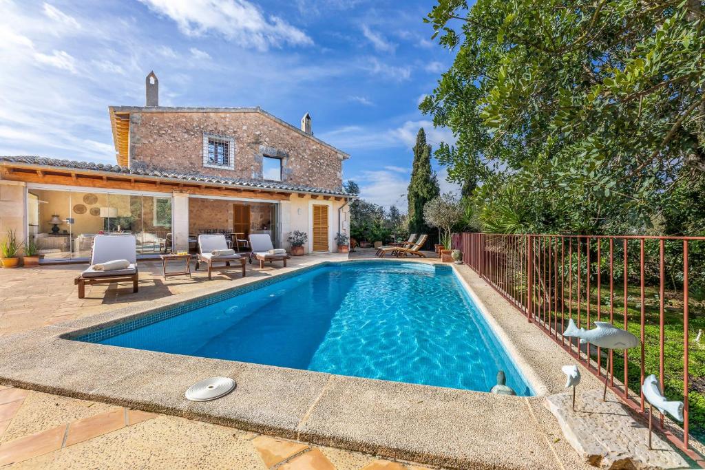 a swimming pool in front of a house at Finca Som Llum in Palma de Mallorca
