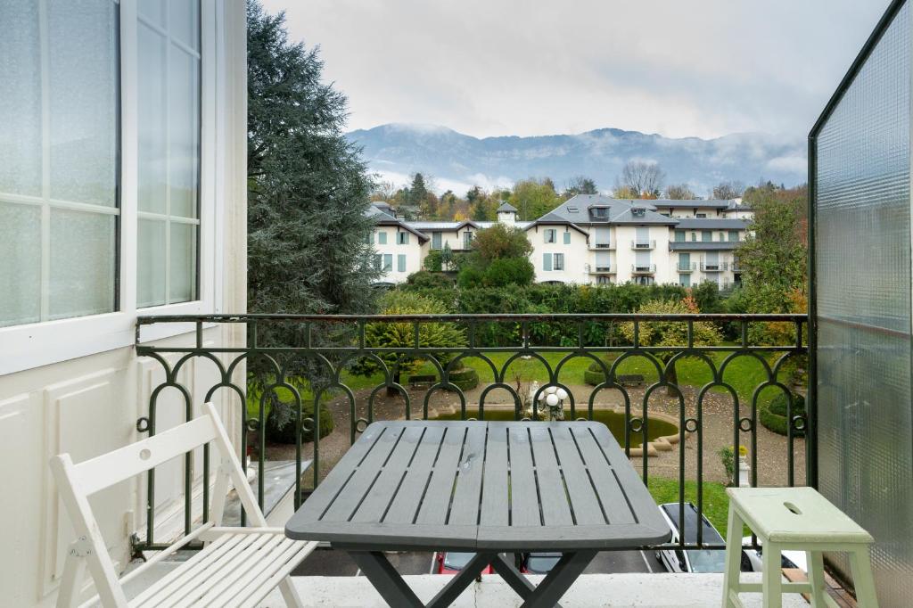 a table and chairs on a balcony with a view at Au Temps Suspendu in Aix-les-Bains