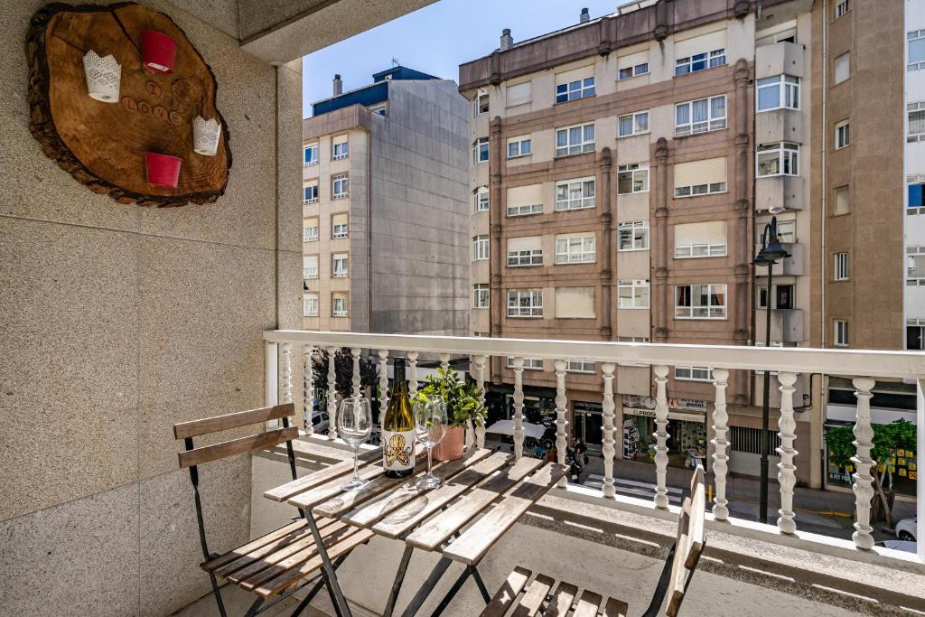a balcony with a table and chairs and a building at O Faro Apartamentos in Ribadeo