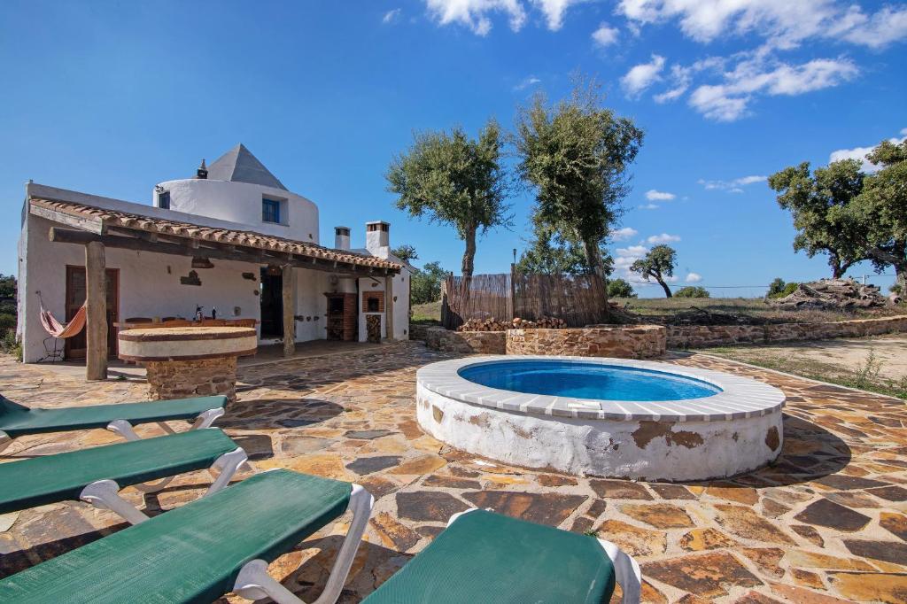 a patio with a pool and chairs and a house at Casa Moinho Da Eira in Loulé