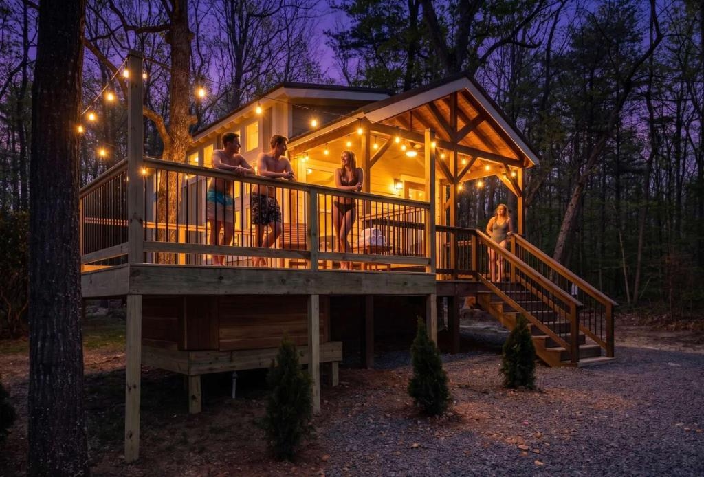 a group of people standing on the deck of a tree house at Hot Tub, Secluded Hickory Tiny Home in Menlo! in Menlo