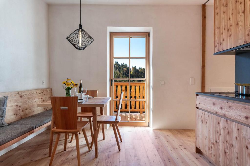 a kitchen and dining room with a table and chairs at Hof im Thal Apt Lärche in Aldino