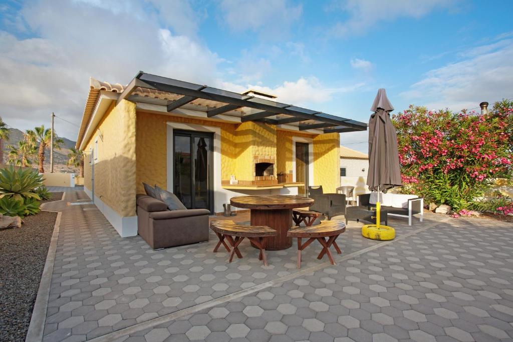 a patio with a table and an umbrella at Recanto Dourado in Porto Santo