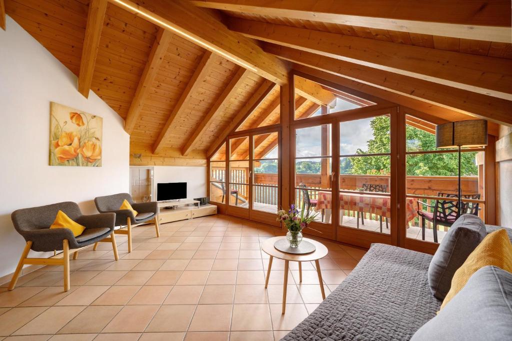 a large living room with wooden ceilings and windows at Stettnerhof Wohnung Penegal in Vollan