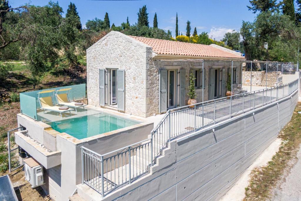 a house with a swimming pool on a fence at The Olive Yard Corfu Sidari in Karousádes