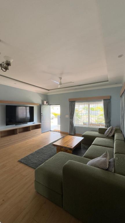 a living room with a couch and a coffee table at Yak villa in Kushālnagar