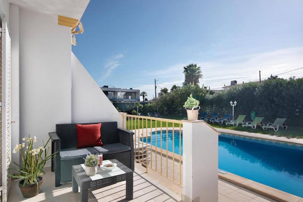 a balcony with a chair and a swimming pool at Villa Martinique in Albufeira