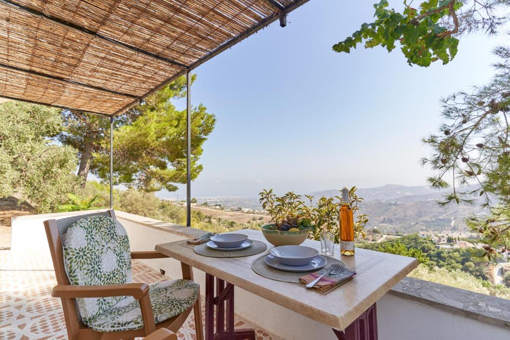 a table and chairs on the balcony of a house at Cortijo de Arriba in Frigiliana
