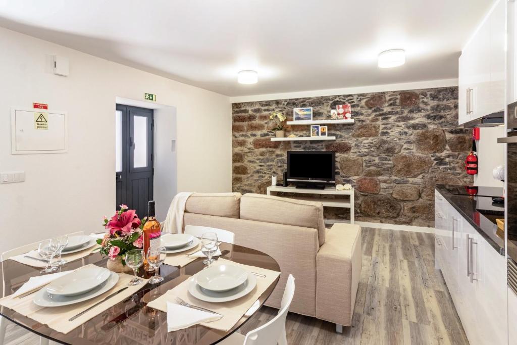 a living room with a table and a couch at Casa do Porto in Paul do Mar