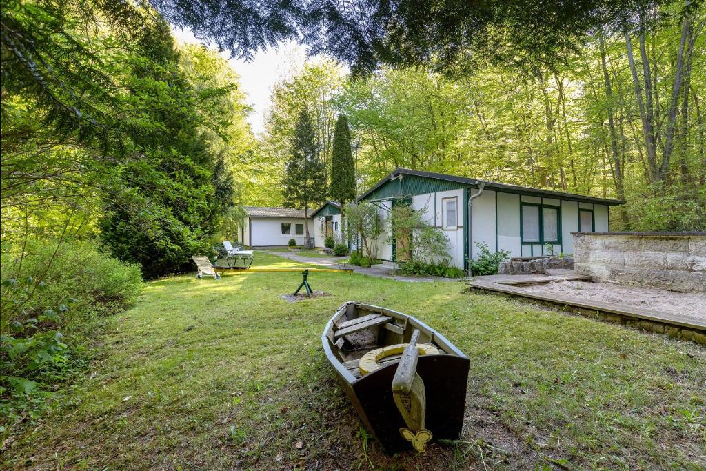a boat sitting in the grass in front of a house at Ferienbungalow 2 in Boitzenburg in Boitzenburg