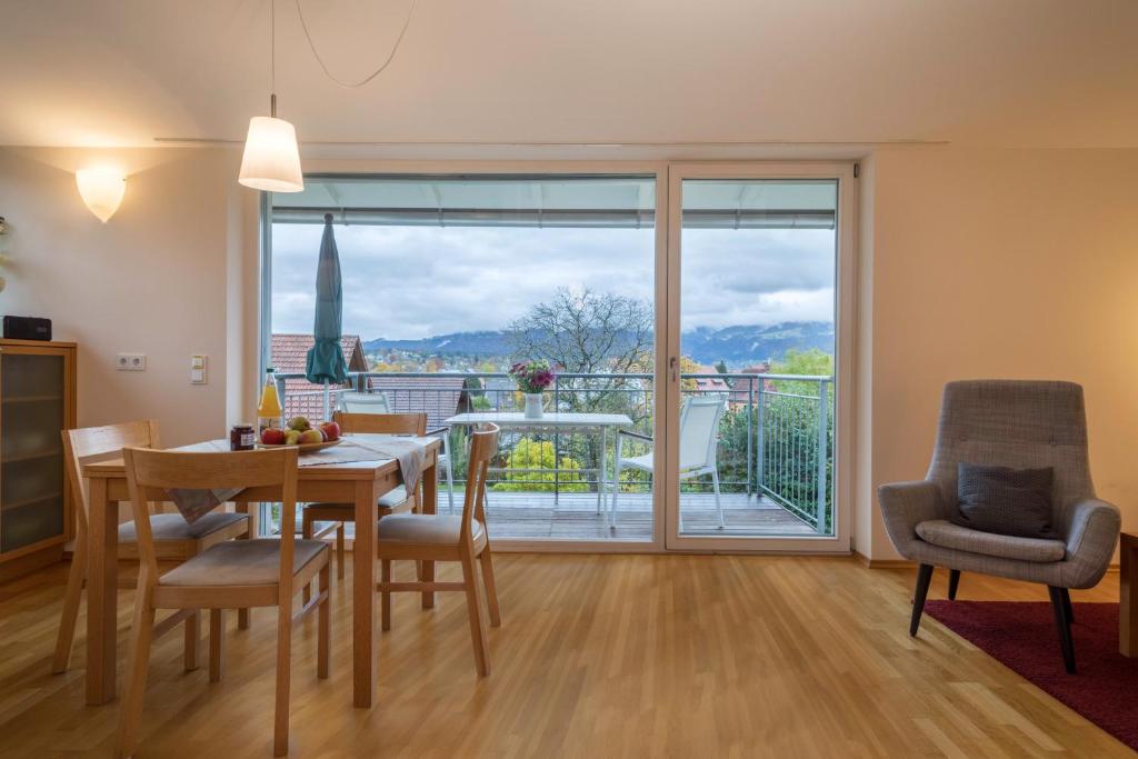 a dining room with a table and chairs and a balcony at Pfirsichblüte in Lindau