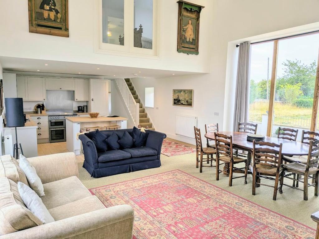 a living room with a blue couch and a table at Salton Lodge Barns in Great Edston