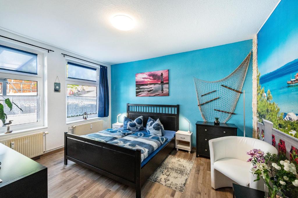 a bedroom with a bed and a blue wall at Charmante 32 m² Ferienwohnung in Barth