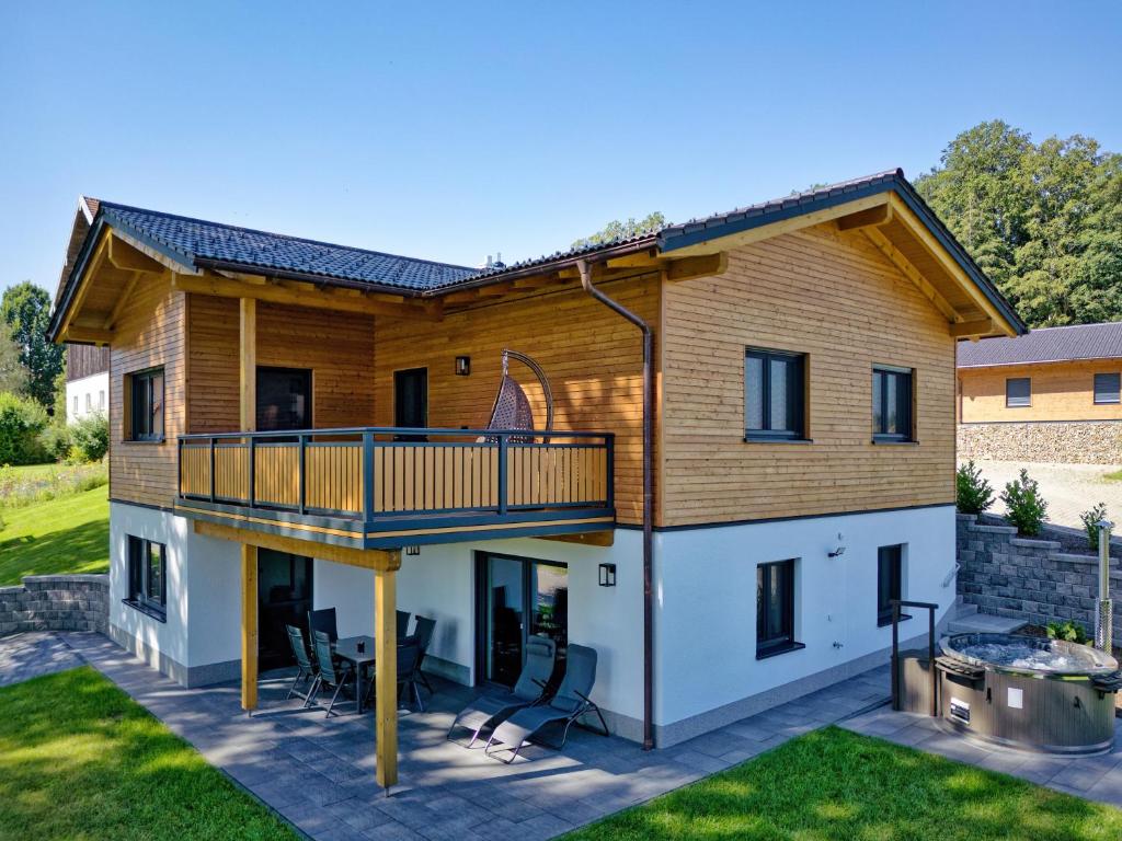 a house with a deck and a patio at Luxus Chalet Landhaus Rachelblick in Eppenschlag