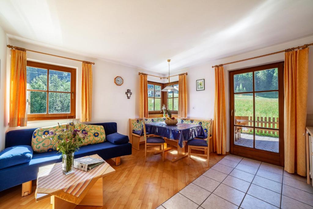 a living room with a blue couch and a table at Rieglhof Apartment Geiernest in Curon Venosta