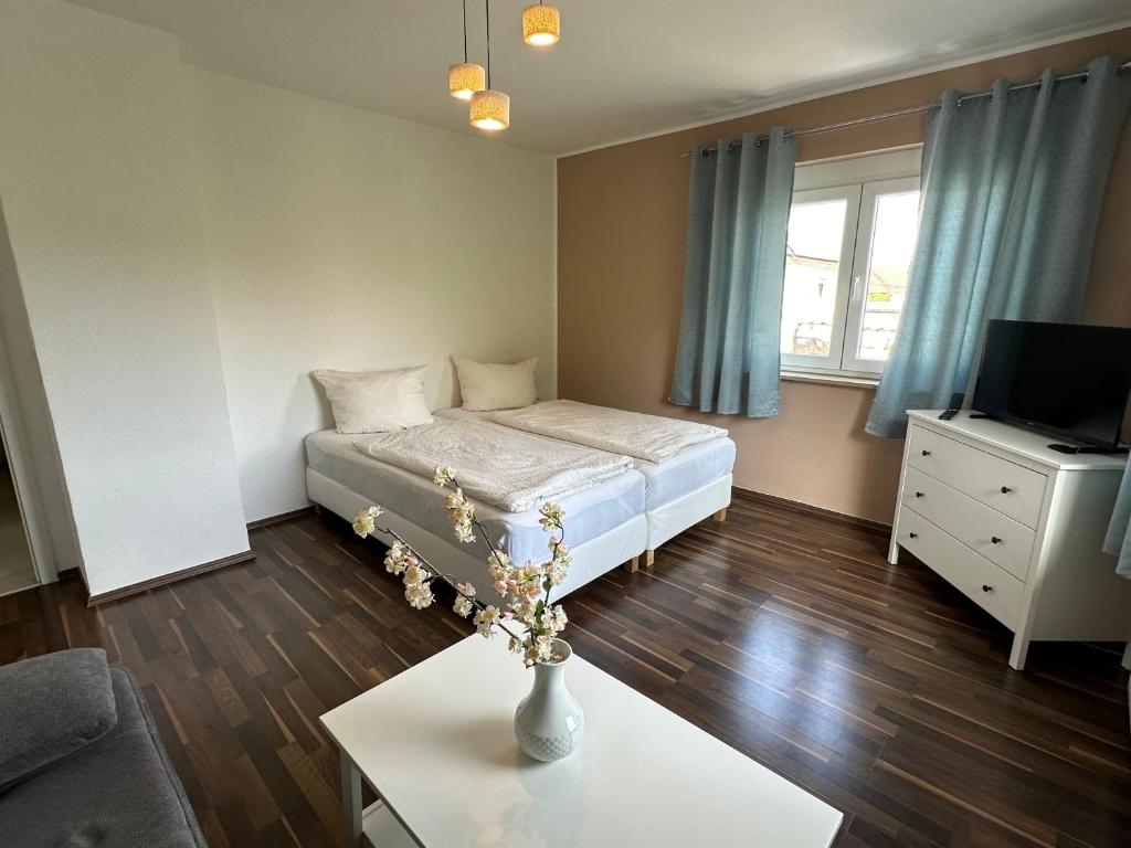 a bedroom with a bed and a vase with flowers on a table at Dreams im Obergeschoss in Koetz 